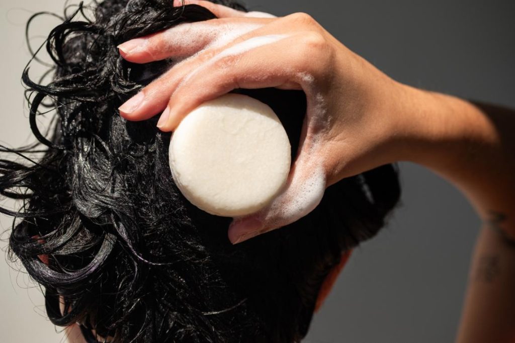 Faire mousser la barre de shampooing dans les cheveux